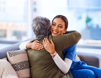 elderly woman hugging a caregiver