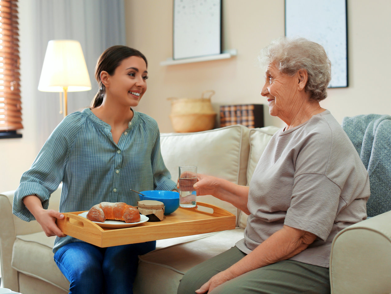 woman serving food for elderly woman