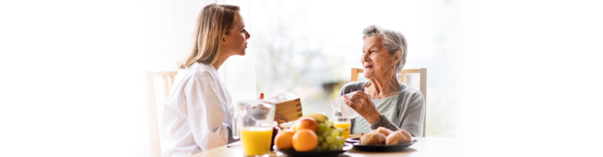 woman and elderly woman talking in dining area