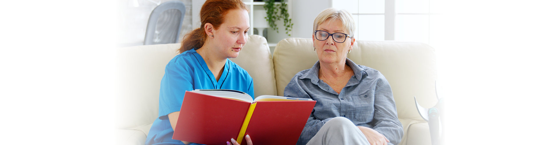 woman reading something while elderly woman listening